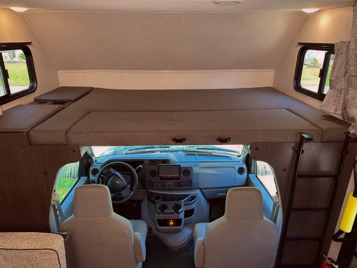 Spacious RV rental interior with a large bunk bed over the cab area, offering comfortable sleeping and travel.. Forest River Solera 2021