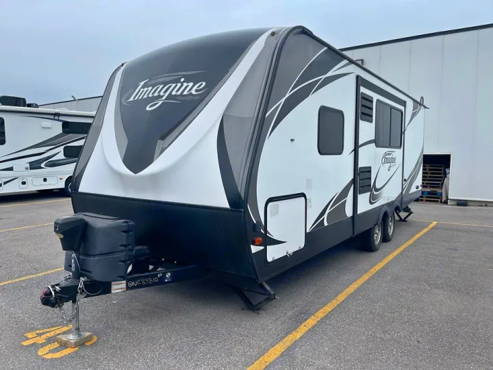 A sleek white & black Imagine travel trailer, ready for RV rental, is parked outdoors. Perfect for your next adventure.. Grand Design Other 2018