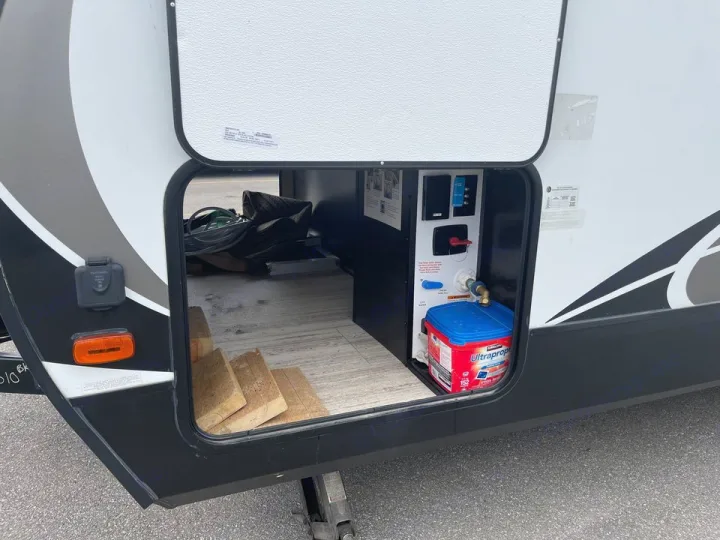 RV rental: Open storage reveals essential utility hookups, antifreeze, and leveling blocks for camping.. Grand Design Other 2018