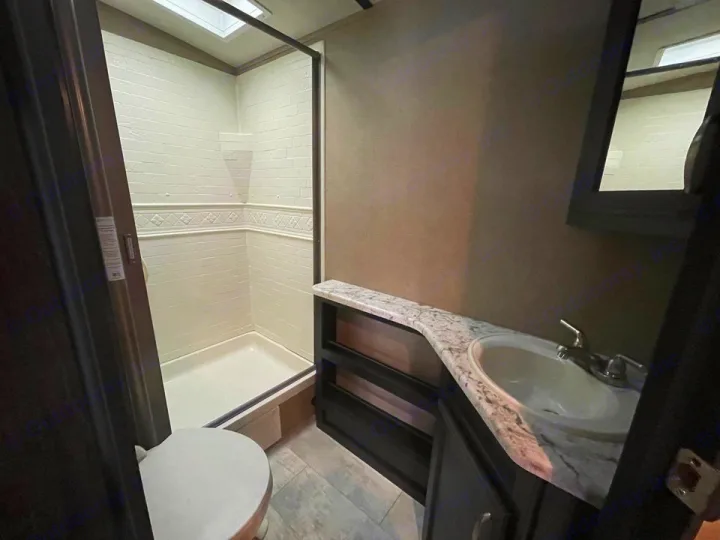 This RV rental bathroom features a shower, toilet, and vanity with a sink & mirror. Ideal for your next trip!. Grand Design Other 2018