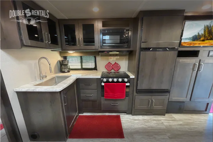 Modern RV rental kitchen with full appliances including fridge, microwave, and stove for comfortable trips.. Grand Design Transcend 2022