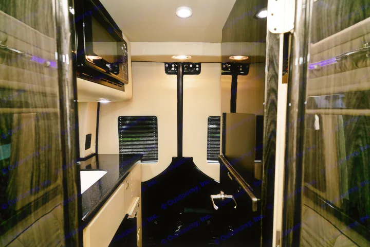 Luxury rv rental van interior featuring a modern kitchen with a microwave and sink, perfect for comfortable travel.. Ultimate Toys Ultimate Coach 2024