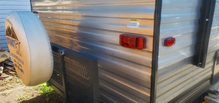 RV rental rear view with spare tire, mesh platform, and a caution label for trailer load limits. Safety details.. Forest River Salem FSX 2019