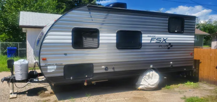 A modern gray Forest River travel trailer, perfect for your next RV rental, parked outdoors on a sunny day.. Forest River Salem FSX 2019