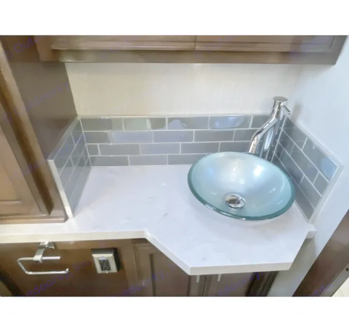 RV rental bathroom vanity: glass vessel sink, chrome faucet, and gray subway tile backsplash on a light countertop.. Newmar Ventana 2023