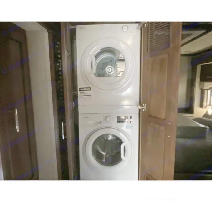 White stacked washer/dryer unit inside a compact space, a feature often found in an RV rental for easy laundry.. Newmar Ventana 2023