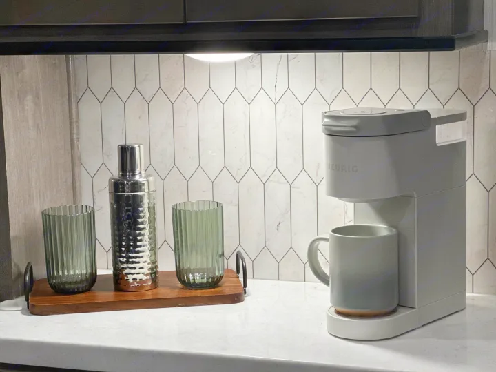 Stylish RV rental kitchenette with a Keurig coffee maker, cocktail shaker, and green fluted glasses. Modern design.. Cedar Creek Cedar Creek Fifth Wheel 2022