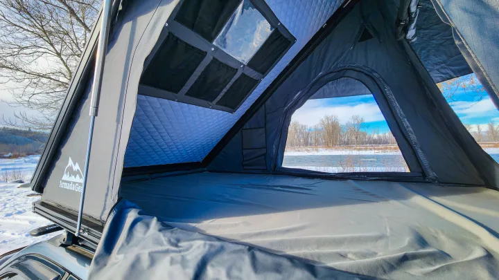 Cozy interior of a rooftop tent set in a winter wonderland, offering a unique alternative for an RV rental adventure.. Toyota Highlander 2003