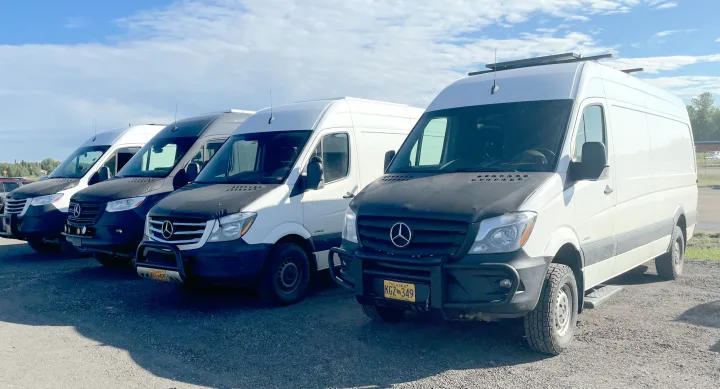 A fleet of white Mercedes-Benz Sprinter vans, ready for adventure as RV rentals, parked in a row on a sunny day.. Mercedes Sprinter 2017
