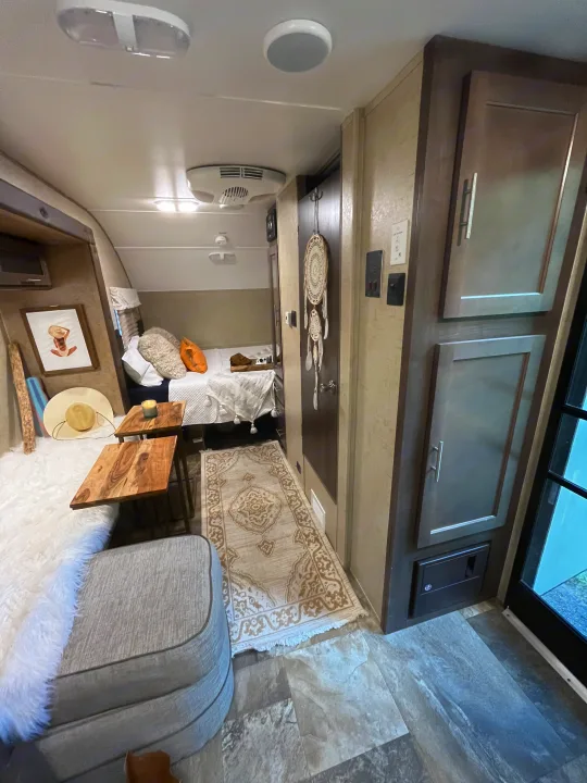 Step inside this cozy RV rental interior! Features a bed, plush rug, and homey decor, perfect for comfortable adventures.. R-Pod Hood River Edition 2016