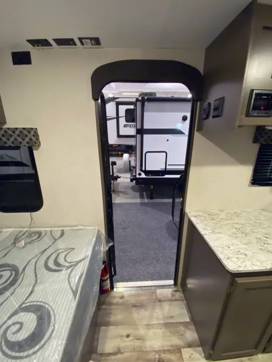 RV rental interior view: new mattress, wood-look floor, and counter.. KZ Sportsmen Classic 180BH 2024