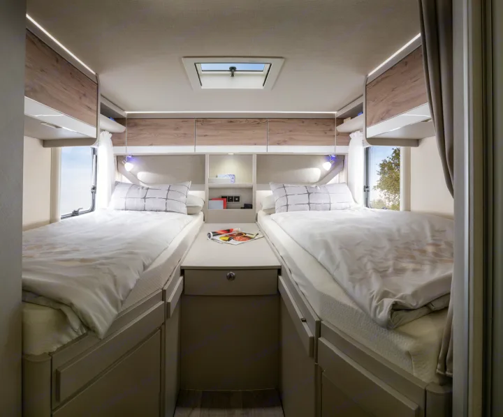 Twin beds and ample storage in a cozy RV rental bedroom, perfect for comfortable travel and adventure.. Hymer Exis I 678 2024