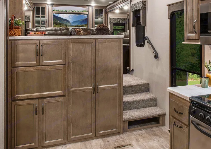 Cozy RV rental interior featuring a full kitchen, ample storage, and carpeted stairs leading to a comfortable living space.. K-Z Manufacturing Durango 2017