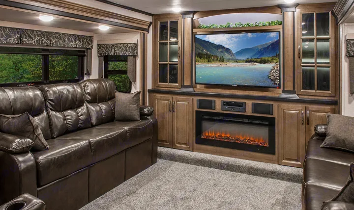 Cozy rv rental living space with a large leather sofa, entertainment system, electric fireplace, and nature views.. K-Z Manufacturing Durango 2017