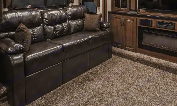 RV rental: Relax in this cozy living area with a dark, cushioned sofa, plush carpet, and entertainment unit with fireplace.. K-Z Manufacturing Durango 2017