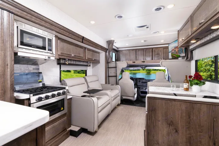 Spacious rv rental interior: kitchen with microwave/oven, recliners, dining area, and front bunk. Ideal for your next road trip.. CONQUEST 6320D 2024