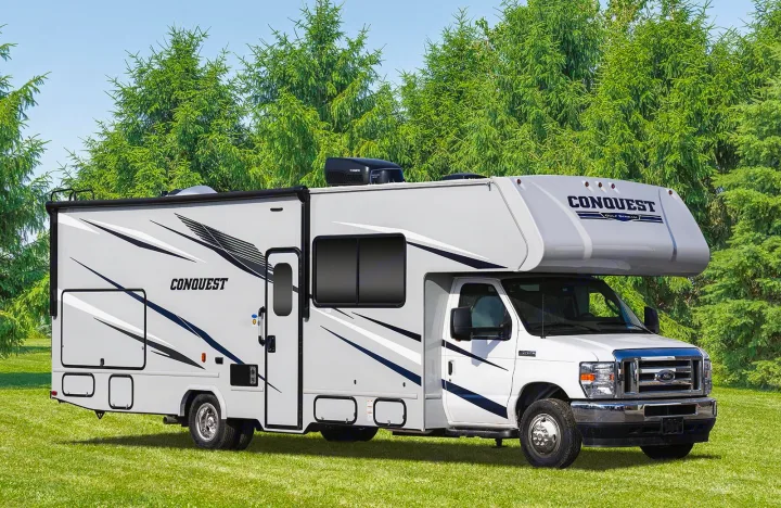 A white Conquest Class C RV rental with gray graphics, parked on grass. Ideal for your next motorhome adventure.. CONQUEST 6320D 2024