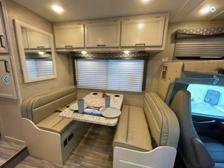 Comfortable RV rental dinette. Spacious interior with seating, table, and storage for your next adventure.. Thor Freedom Elite 2023