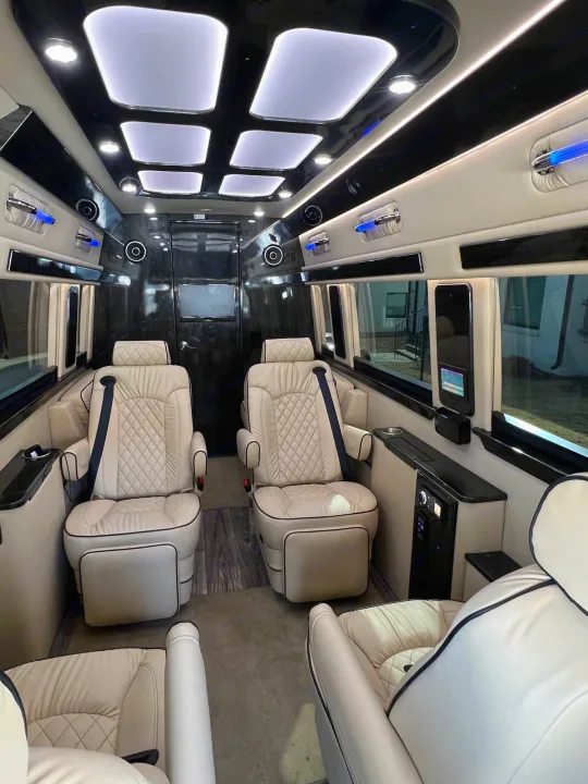 Cream-colored, quilted leather seats fill this luxurious RV rental interior, featuring bright ceiling panels & blue accent lights.. Ultimate Toys Ultimate Coach 2023