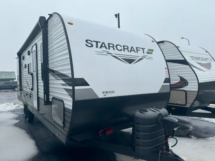 Front exterior of a white and black StarCraft travel trailer, ideal for rv rental, parked in a snowy lot.. Starcraft 26BHS 2024