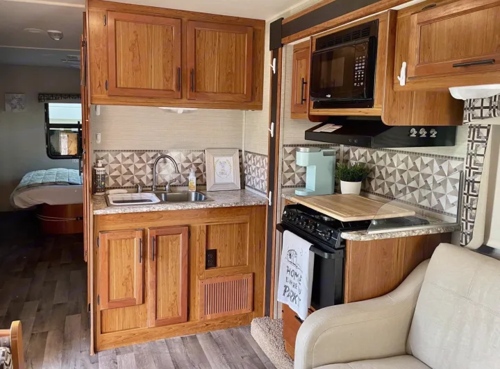 Cozy RV rental interior: fully equipped kitchen, living area, and bedroom beyond.. Jayco Redhawk 2017