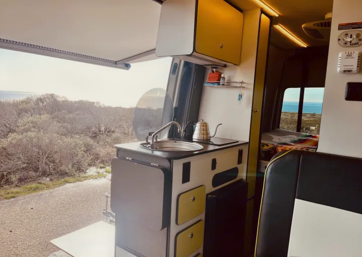 RV rental kitchen: sink, kettle, and an ocean view from the opened door. Perfect for mobile travel!. Winnebago Revel 2019