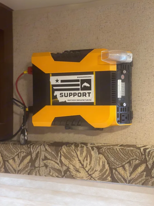 A yellow power inverter is wall-mounted inside an RV rental, providing essential electricity for devices and appliances.. Jayco Jay Flight SLX 2015