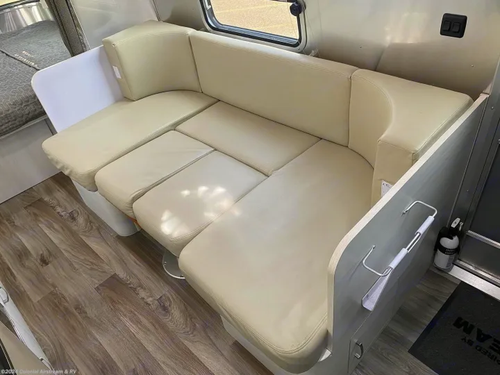 Airstream RV rental interior: Light cream U-shaped dinette seating, wood-look floor, and versatile lounge space.. Airstream Sport 2019