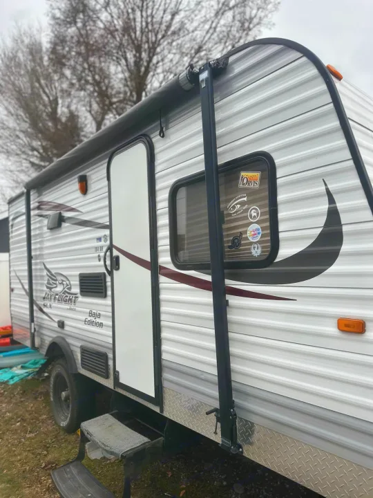 This white Jay Flight SLX Baja Edition travel trailer, seen from the side, is an excellent rv rental option for camping adventures.. Jayco Jay Flight SLX 2015