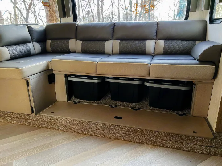 This RV rental's interior features L-shaped dinette seating in gray/beige, revealing clever under-seat storage with black bins.. Forest River Salem 2022
