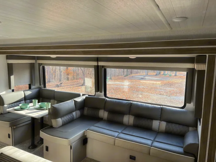 Spacious RV rental interior: a U-shaped dinette with table and comfortable seating, offering scenic views.. Forest River Salem 2022