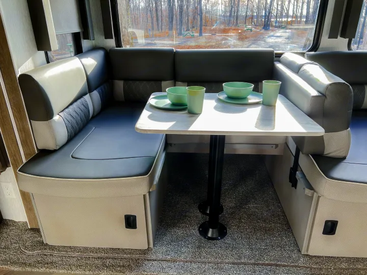 RV rental dinette featuring U-shaped seating, a dining table, and a window with a clear view of nature.. Forest River Salem 2022