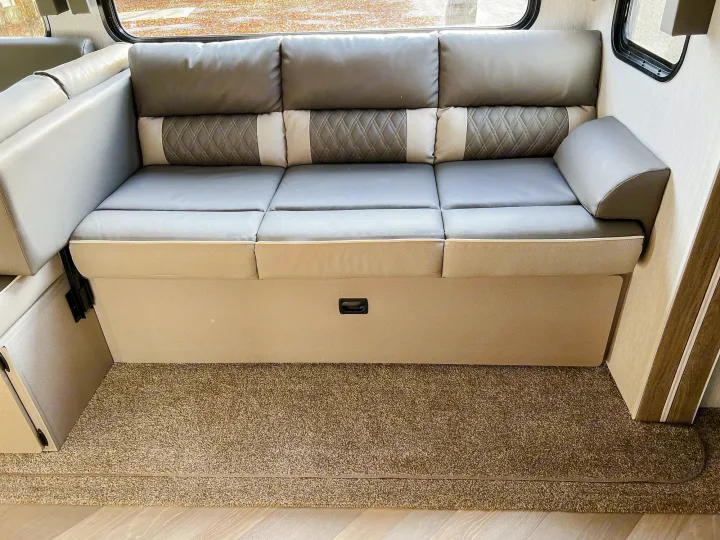 RV rental: Modern gray sofa with patterned backrests & storage. Comfortable seating for travel adventures.. Forest River Salem 2022