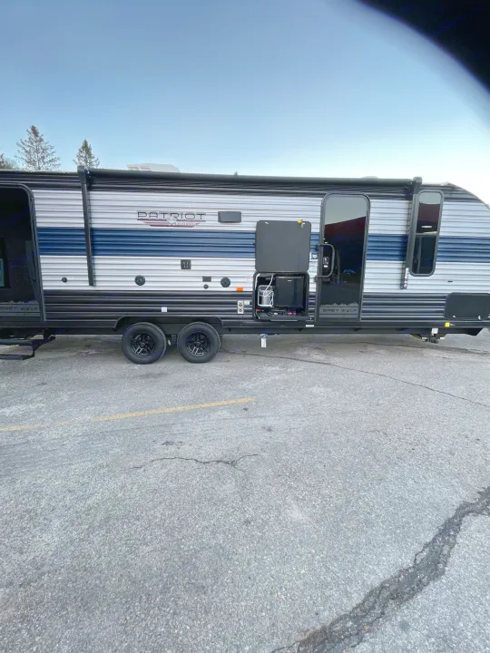 This Grey Wolf Patriot Edition RV rental features a convenient outdoor kitchen, perfect for camping trips.. Forest River Patriot 26DBH 2022