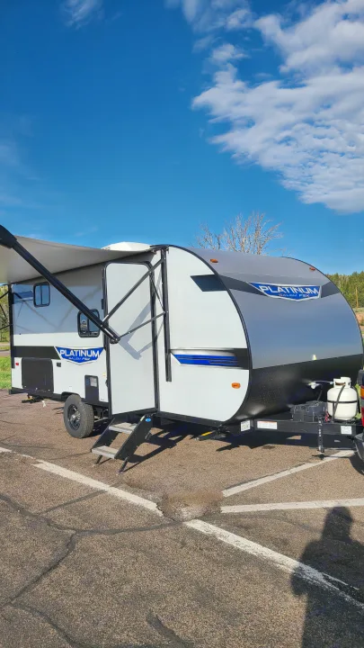 Bright, new Platinum travel trailer, perfect for an RV rental outdoor adventure. Awning out on sunny day.. Forest River Salem FSX Plantium 2022