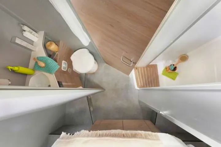 Compact RV rental bathroom featuring a toilet, sink, and shower area, designed for travel convenience.. Dethleffs Just T7052 DBM 2024
