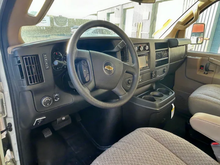 RV rental driver's cockpit view: steering wheel, dashboard controls, infotainment screen, and front seats.. Thor Freedom Elite 22HE 2020