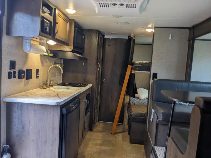 Inside this cozy RV rental: a kitchen with sink and stove, dinette seating, and bunk beds. Ready for your adventure.. Jayco Jay Flight SLX 2020