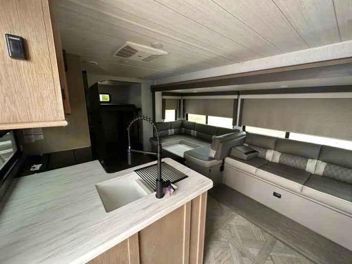 This RV rental interior showcases a full kitchen, spacious seating, and a private sleeping nook, ideal for travel.. Forest River Salem Platinum 2024