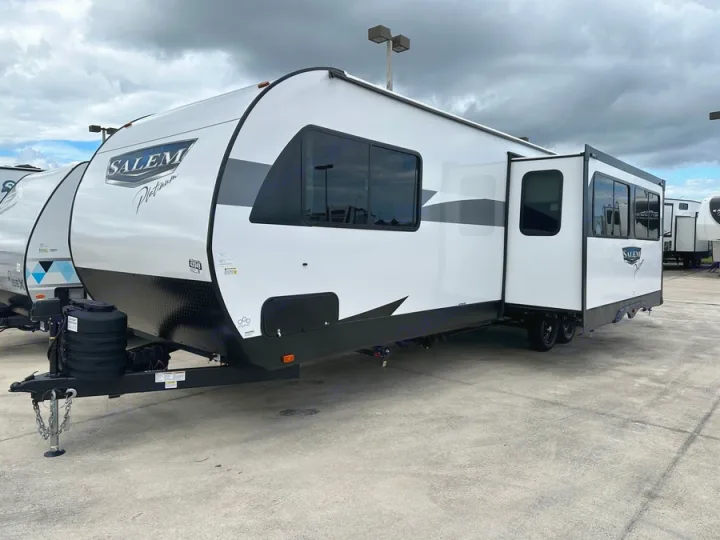 White Salem Platinum travel trailer with an extended slide-out, parked on a concrete lot. Perfect for rv rental.. Forest River Salem Platinum 2024