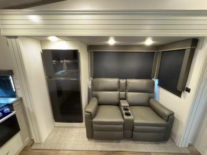 This RV rental offers a cozy interior with recliners, a large refrigerator, and a well-equipped kitchen corner for travelers.. Other Other 2024