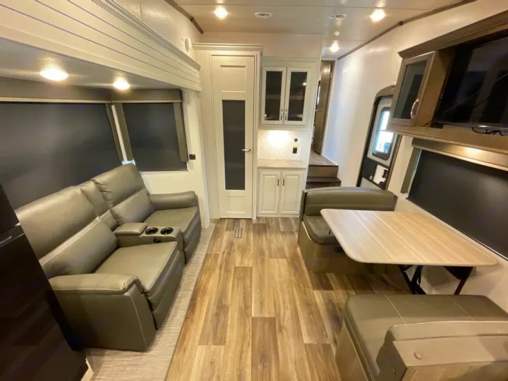 Spacious RV rental interior with recliners, dining booth, and kitchenette. Modern and comfortable living space.. Other Other 2024