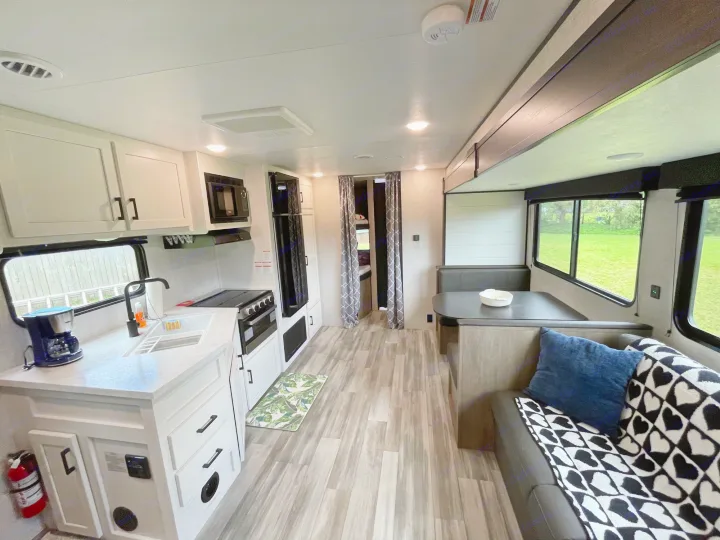 Spacious RV rental interior featuring a modern kitchen, comfortable dining booth, and cozy living space.. Jayco Jay Flight 261BHS 2024
