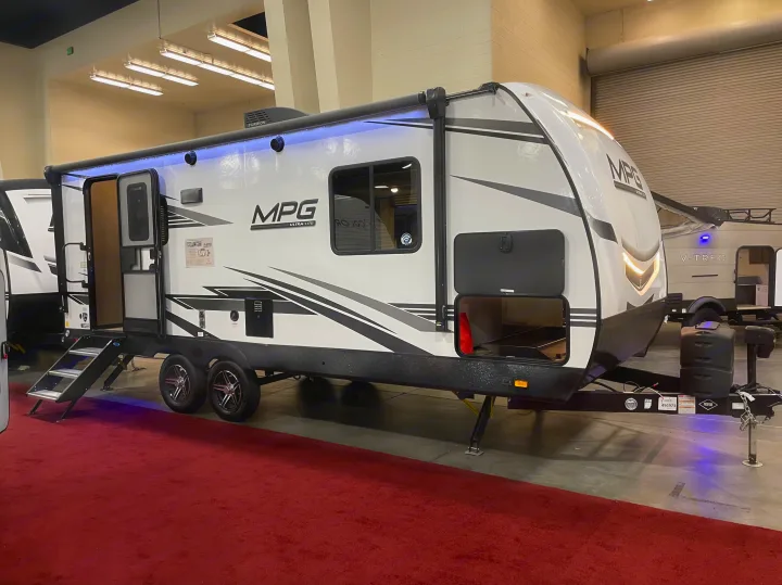 This white MPG Ultra-Lite travel trailer, perfect for an RV rental, features open steps, side door, and storage for camping.. Cruiser RV MPG Ultra Lite 2022