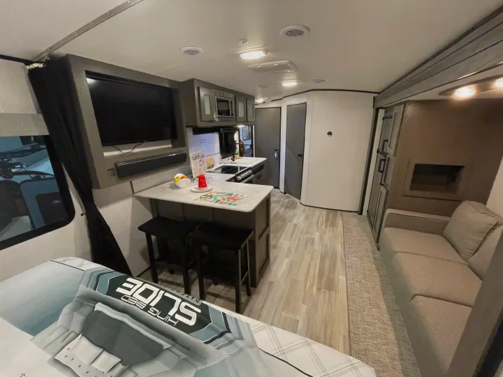Modern RV rental interior showing kitchen, living room, and bedroom area.. Cruiser RV MPG Ultra Lite 2022
