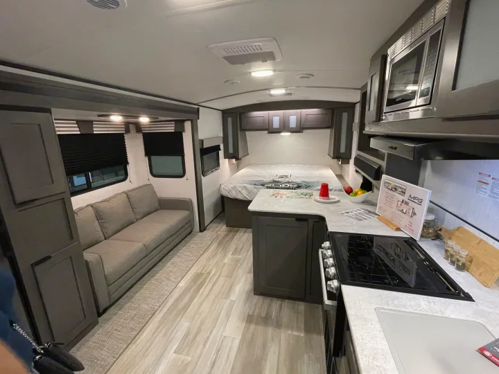 Modern RV rental interior: cozy living area, full kitchen, and bed, offering comfort on the road.. Cruiser RV MPG Ultra Lite 2022