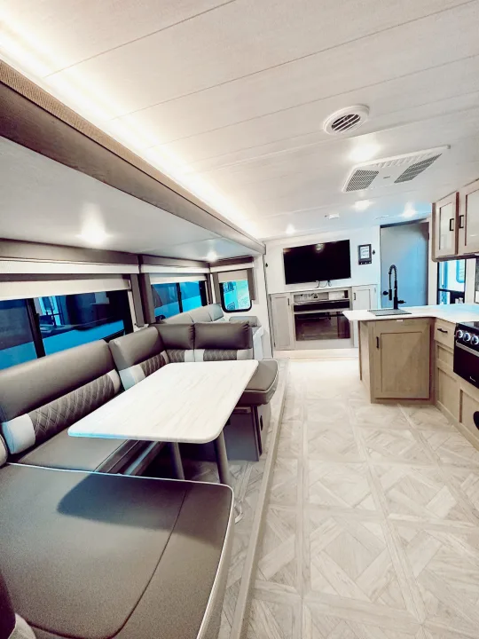 Step inside this modern RV rental! Features a comfy booth dinette, full kitchen, and living area with TV & fireplace.. Forest River Wildwood X-Lite Platinum 2024