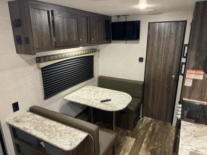 RV rental: Cozy interior showing dinette, overhead cabinets, TV, and partial kitchen.. Starcraft Autumn Ridge Outfitter 2020