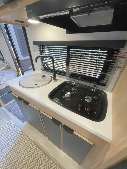 RV rental: Compact kitchenette with sink, two-burner Suburban stove, and Greystone vent hood for on-the-go meals.. Cruiser RV Hitch 2022