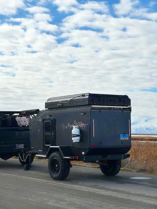 Get this **RV rental**! A rugged, dark **overland camping trailer** with a rooftop tent, ready for mountain adventures.. Other Other 2024